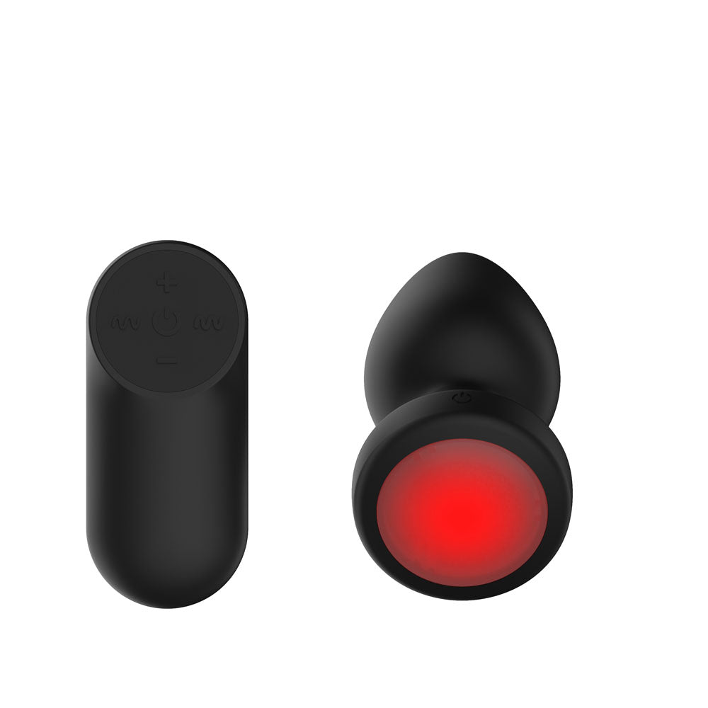 Underside view of Passion Play medium butt plug with its round red LED base and remote